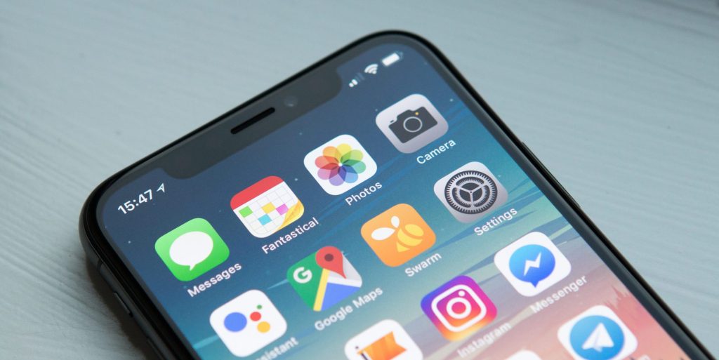 smartphone with home screen showing various apps